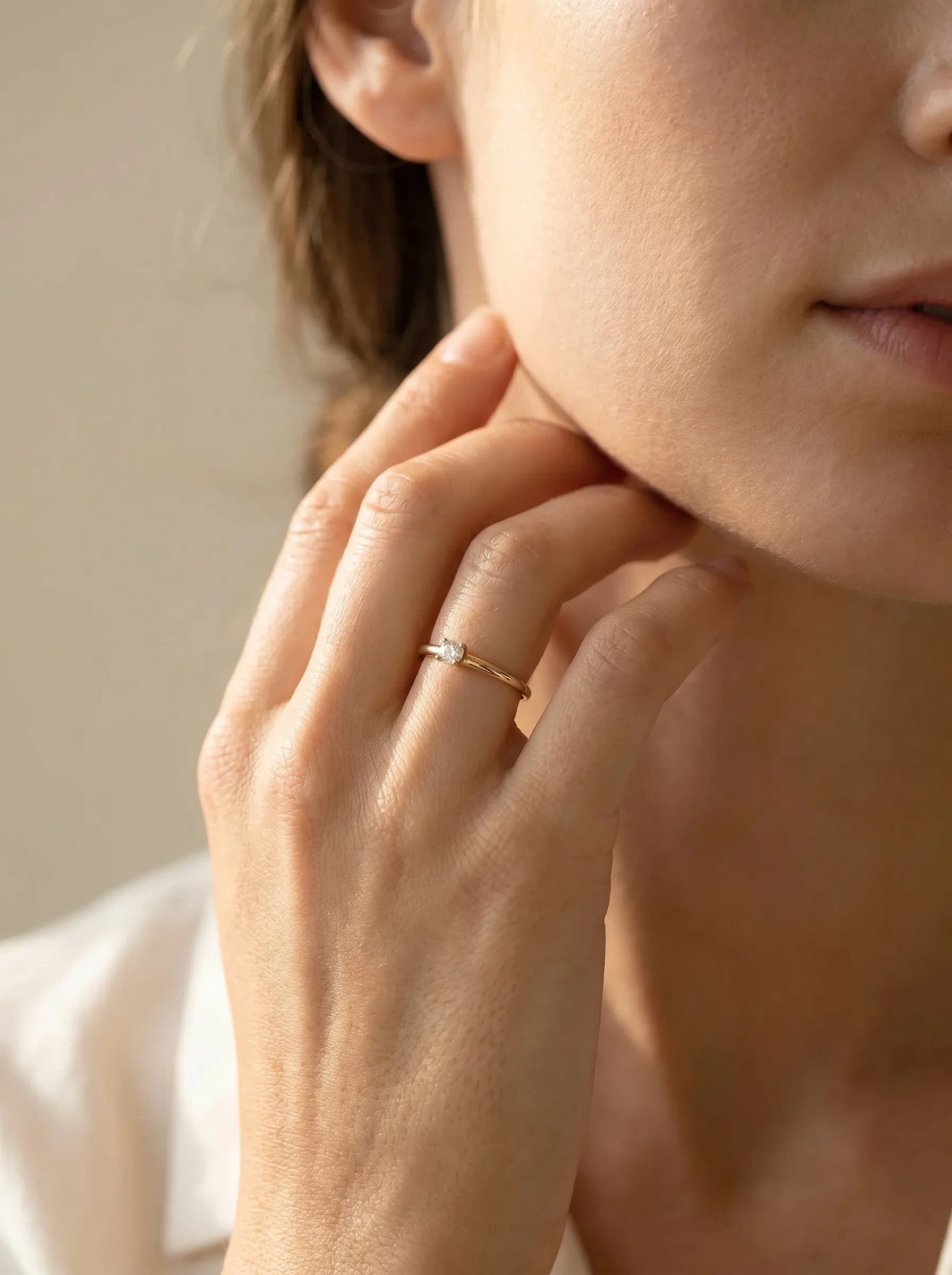 A gold ring photographed in the Hand to face composition
