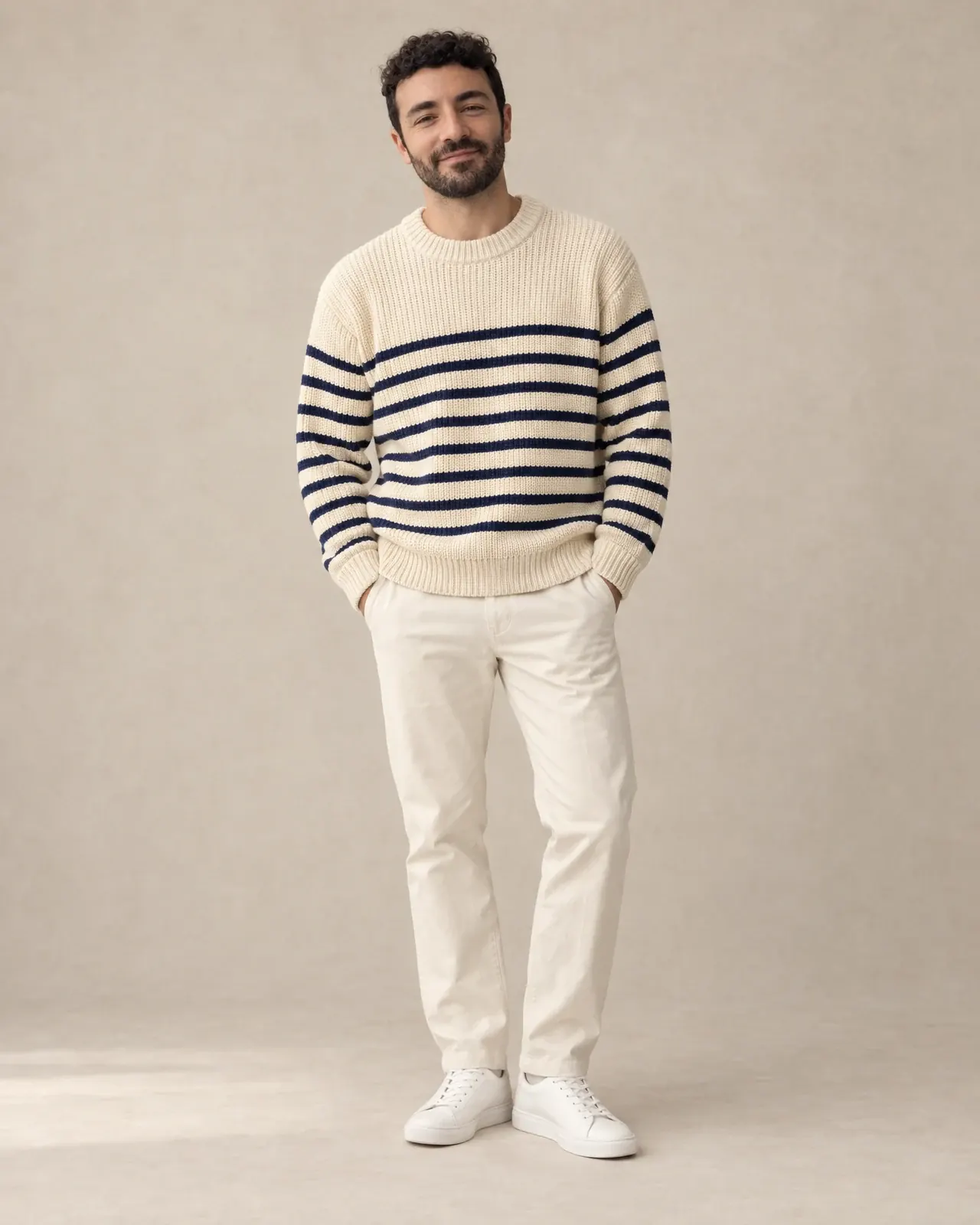 The same man as a custom AI fashion model, wearing a striped fisherman sweater in a warm studio.