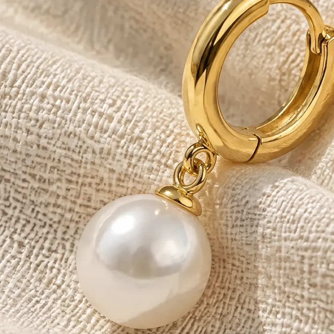 The same gold huggie, bail and pearl drop in an AI jewelry photography macro on cream linen.