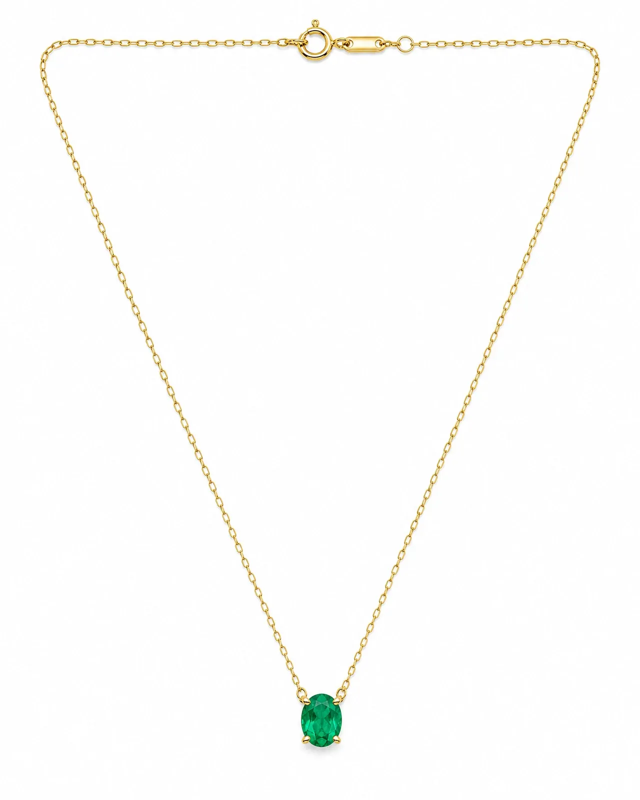 The original packshot: a gold chain necklace with an oval emerald pendant laid flat on white.